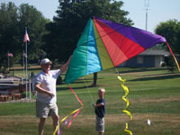 Groton back pain free grandpa and grandson playing with a kite
